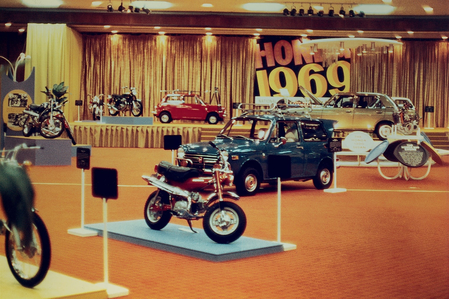 The Honda Heritage Center lobby from the '60s, with '1959' visible in the background and some beautiful classic Honda motorcycles and car models in the foreground.